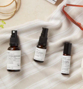 3 skincare travel sizes on a white towel