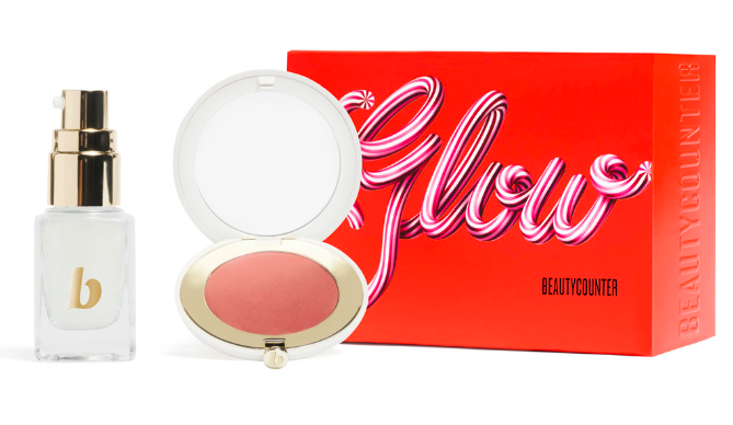 a red holiday box with a clamshell blush to the left and a mini glass bottle left of that
